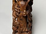 statue en bois représentant une femme tenant un chat et un oiseau perché sur une branche