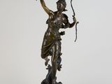 une statue en bronze représentant une femme tenant un arc et une flèche