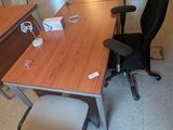 une photo d'un bureau vide avec un bureau et des chaises