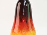 a red and yellow vase sitting on a white surface
