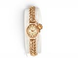 an image of a gold wrist watch with a chain around it