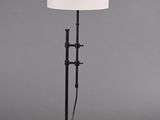 lampe sur pied avec un abat-jour blanc monté sur un pied noir et un corps de lampe cylindrique blanc