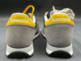 a close up of a pair of shoes with a yellow shoelace