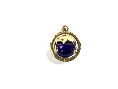 un gros plan d'une théière bleue sur un pendentif plaqué or