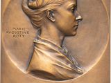 plaque en bronze représentant une femme avec une mèche de cheveux et une mèche de cheveux