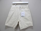 the white shorts are hanging on a hanger on the wall