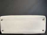 a white purse sitting on top of a black table