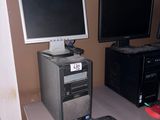 un ordinateur de bureau posé sur un bureau, à côté d'un écran et d'un clavier