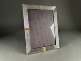 silver and gold photo frame with hearts on it on a table