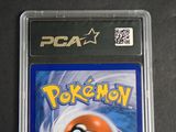the pokemon card is in a plastic holder on a table