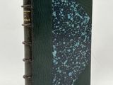 a black book with a green cover and a blue design on it