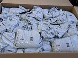 a cardboard box filled with bags of clothes on the floor