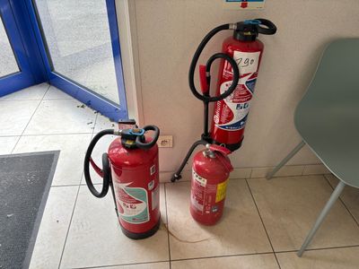 two fire extinguisors sitting next to each other on the floor