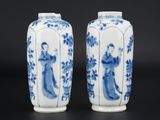 une paire de vases bleus et blancs ornés de personnages