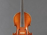 an old violin sitting on a stand against a gray background