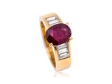 a close up of a ring with a ruby stone and baguets