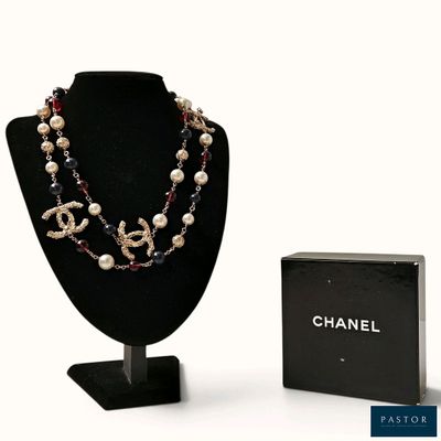 un collier de perles et une boîte posée sur la table