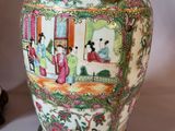 a vase with a painting on it sitting on a table
