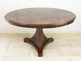 a round table with a wooden base on a tiled floor