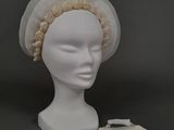 une tête de mannequin blanche coiffée d'un chapeau blanc