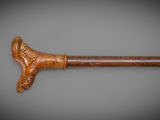 an old cane with a wooden handle on a gray background
