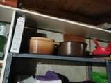 de nombreuses casseroles et poêles sur une étagère dans la cuisine