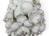 a white sculpture of a bunch of fruit on a white surface