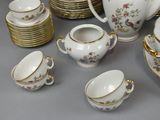 many different types of porcelain dishes and cups on the table