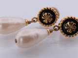 a close up of a pair of earrings with pearls on them