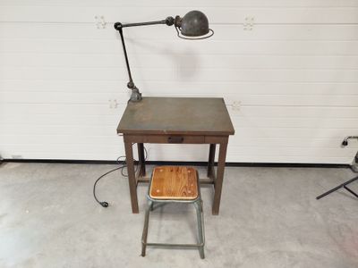 un bureau avec un tabouret et une lampe dans un garage