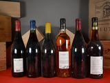 several bottles of wine are lined up on a table in front of boxes
