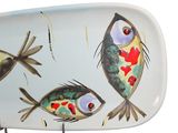 a plate with a fish design on it on a stand