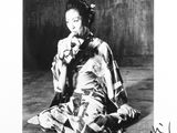 black and white photograph of a woman in a kimono sitting on the floor