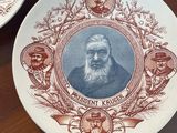 three plates with portraits of presidents on them on a wooden table