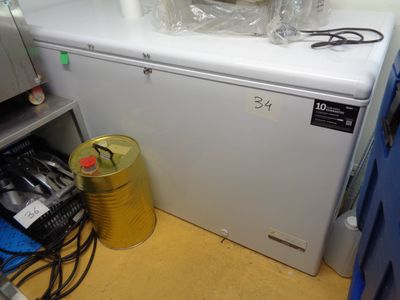un petit réfrigérateur blanc dans le coin d'une pièce