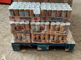 Plusieurs canettes de bière sont empilées sur une palette dans un entrepôt