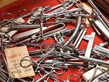 several pairs of scissors are in a wooden box on a red cloth