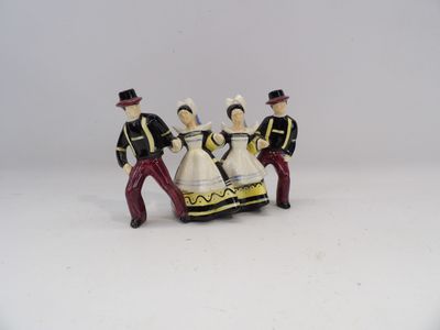 trois figurines représentant des personnes vêtues de costumes traditionnels