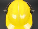 an image of a yellow hard hat sitting on top of a black table