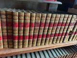 many old books on a wooden shelf in a library