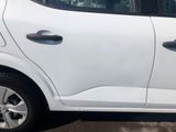 a white car parked in a parking lot with trees in the background