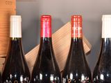several bottles of wine are lined up on a shelf next to a wooden box
