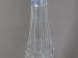 a clear glass vase with a bird on top of it
