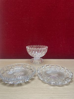 three glass dishes on a table with a red wall in the background