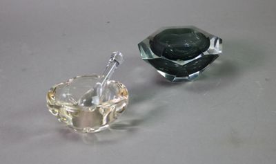 two glass ashtrays sitting on a table next to each other