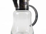 a clear glass pitcher with a metal lid and a black handle