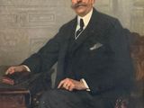 portrait d'un homme en costume, assis sur une chaise