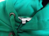 a close up of a green hoodie with a tag on it