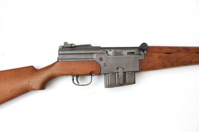 gros plan d'un fusil sur une surface blanche