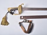 une vieille épée à l'extrémité de laquelle pend un pompon